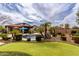Expansive backyard with a pool, putting green, lush landscaping, and charming desert vibes at 560 W Powell Way, Chandler, AZ 85248