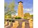 Stone clock tower surrounded by manicured landscaping, with lush green trees and blue skies at 560 W Powell Way, Chandler, AZ 85248