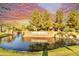 Scenic Fulton Ranch entrance with brick signage, water feature, mature trees, and vibrant sunset at 560 W Powell Way, Chandler, AZ 85248