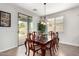 Dining room with access to the backyard, elegant dark wood table, seating, and window with plantation shutters at 560 W Powell Way, Chandler, AZ 85248