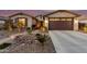 Charming home exterior featuring a well-manicured front yard with stone accents and a spacious two-car garage at 560 W Powell Way, Chandler, AZ 85248