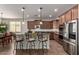 Charming kitchen with brown cabinets, granite countertops, stainless steel appliances, and stylish island seating at 560 W Powell Way, Chandler, AZ 85248