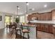 Bright kitchen featuring wooden cabinets, granite counters, island with seating, and adjacent dining area at 560 W Powell Way, Chandler, AZ 85248