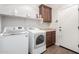 Well-equipped laundry room with modern washer and dryer, built-in cabinets, and countertop space at 560 W Powell Way, Chandler, AZ 85248