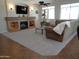 Inviting living room featuring a stone fireplace with custom shelving and neutral colored carpeting at 560 W Powell Way, Chandler, AZ 85248