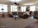 This living room opens to the dining area, has plush carpets, a ceiling fan, and lots of natural light at 560 W Powell Way, Chandler, AZ 85248