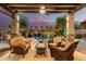 Inviting covered patio with comfortable seating overlooking a sparkling pool and lush landscaping, perfect for outdoor relaxation at 560 W Powell Way, Chandler, AZ 85248