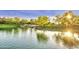 Picturesque pond with a small waterfall and mature trees with the sun shining through the leaves at 560 W Powell Way, Chandler, AZ 85248
