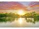 Picturesque pond view reflecting the sunset, surrounded by lush greenery, trees and rock features at 560 W Powell Way, Chandler, AZ 85248