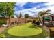 Backyard putting green surrounded by lush landscaping, near the pool at 560 W Powell Way, Chandler, AZ 85248