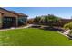 Well maintained backyard featuring lush, green artificial turf and a brick pathway to the side yard at 6112 E Calle De Pompas --, Cave Creek, AZ 85331