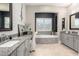 Bathroom with a large tub set in decorative tilework, gray cabinets and a makeup vanity at 6112 E Calle De Pompas --, Cave Creek, AZ 85331