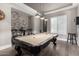 Modern game room featuring a pool table, hardwood floors, and an exposed brick accent wall at 6112 E Calle De Pompas --, Cave Creek, AZ 85331