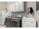 Bright laundry room with modern washer and dryer, practical sink, and ample storage space at 6112 E Calle De Pompas --, Cave Creek, AZ 85331
