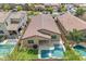 Aerial view of the backyard featuring a pool, covered patio, lawn, desert landscaping, and a barbecue area at 696 W Glen Canyon Dr, San Tan Valley, AZ 85140