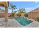 Backyard pool with a tile waterfall feature, complemented by desert landscaping and an adjacent covered patio at 696 W Glen Canyon Dr, San Tan Valley, AZ 85140