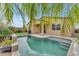 Backyard pool with a covered patio and lush tropical landscaping; ideal for relaxation and entertaining at 696 W Glen Canyon Dr, San Tan Valley, AZ 85140