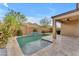 Backyard featuring a pool with a tile waterfall and lush landscaping, perfect for outdoor relaxation and entertainment at 696 W Glen Canyon Dr, San Tan Valley, AZ 85140