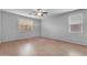 Bright bedroom featuring wood floors, a ceiling fan, and two windows allowing natural light at 696 W Glen Canyon Dr, San Tan Valley, AZ 85140