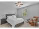 Calm bedroom featuring a wooden bed frame with white bedding, complemented by a woven chair and soft natural light at 696 W Glen Canyon Dr, San Tan Valley, AZ 85140