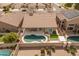 Aerial view shows a home with a backyard pool, covered patio, artificial turf, and desert landscaping at 760 W Douglas Ave, Gilbert, AZ 85233