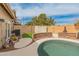 This backyard features a fenced in kidney shaped pool, stone retaining wall, and a small patch of artificial turf at 760 W Douglas Ave, Gilbert, AZ 85233
