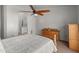 Sunlit bedroom features an arched entrance to the bathroom with a glass door shower and wood furniture at 760 W Douglas Ave, Gilbert, AZ 85233
