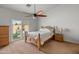 Light bedroom showcases ceiling fan, neutral carpet, and natural light from a glass door to the backyard at 760 W Douglas Ave, Gilbert, AZ 85233