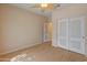 Neutral bedroom features pale walls, wood-look floors, ceiling fan, and a double-door closet at 760 W Douglas Ave, Gilbert, AZ 85233