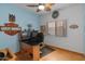 Bedroom with blue walls, wood-look floors, window, desk and a leaf-style ceiling fan at 760 W Douglas Ave, Gilbert, AZ 85233