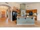 Kitchen island with breakfast bar seating, a black refrigerator and light oak cabinets at 760 W Douglas Ave, Gilbert, AZ 85233