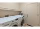 Clean laundry room featuring a white washer and dryer with storage shelf above at 760 W Douglas Ave, Gilbert, AZ 85233