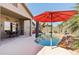 Lush backyard oasis with beautiful pool, rock features, a red sun umbrella and ample space for outdoor dining at 8014 W Ross Ave, Peoria, AZ 85382