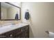 Half-bathroom with a dark vanity, decorative mirror, and modern fixtures at 860 N Mcqueen Rd # 1028, Chandler, AZ 85225