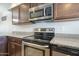 Close up of the kitchen stove features stainless steel appliances and granite countertops at 860 N Mcqueen Rd # 1028, Chandler, AZ 85225