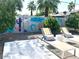 A relaxing backyard space with modern lounge chairs and colorful desert-themed mural at 8738 E Rose Ln, Scottsdale, AZ 85250