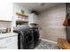 Modern laundry room with front-load washer and dryer, custom cabinets, and designer tile flooring at 8738 E Rose Ln, Scottsdale, AZ 85250