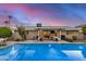 Backyard pool at twilight featuring a covered patio with outdoor seating and a mounted television at 8738 E Rose Ln, Scottsdale, AZ 85250