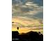 Scenic view of a vibrant sunset over silhouetted mountains and palm trees at 8738 E Rose Ln, Scottsdale, AZ 85250