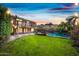 A backyard featuring a well-manicured lawn, a fenced in pool and spa, and a two-story home with a balcony at 9364 S Margo Dr, Tempe, AZ 85284