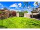 Well-maintained backyard featuring lush green grass, mature trees and flowerbeds offers a serene outdoor space at 9364 S Margo Dr, Tempe, AZ 85284