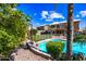 A backyard with citrus trees, plants, rocks, a pool, and a two-story home at 9364 S Margo Dr, Tempe, AZ 85284