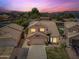 Stunning two-story home with a tile roof, lush landscaping, and mountain views at sunset at 9364 S Margo Dr, Tempe, AZ 85284