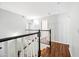 Bright hallway with hardwood floors, black and white banister and an open doorway at 9364 S Margo Dr, Tempe, AZ 85284