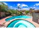 A fenced in pool and spa sit in a backyard with lush landscaping and a two-story home at 9364 S Margo Dr, Tempe, AZ 85284
