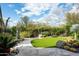 Serene backyard with artificial turf, a decorative water feature, and lush desert landscaping at 9722 E Mark Ln, Scottsdale, AZ 85262