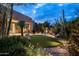 Beautiful backyard with artificial grass, desert landscaping, water feature and outdoor lighting at 9722 E Mark Ln, Scottsdale, AZ 85262