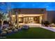 The backyard features artificial turf, mature cactus, a patio and inviting outdoor living space at 9722 E Mark Ln, Scottsdale, AZ 85262
