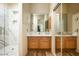 Elegant bathroom featuring marble countertops, wood cabinetry, and a glass-enclosed shower with modern fixtures at 9722 E Mark Ln, Scottsdale, AZ 85262