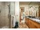 Bathroom featuring a glass-enclosed shower and light wood cabinets with granite countertops at 9722 E Mark Ln, Scottsdale, AZ 85262